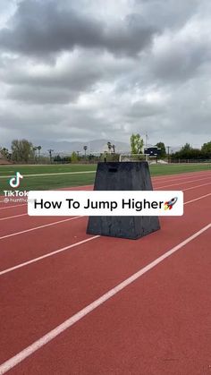 a black box sitting on top of a red track next to a white sign that says how to jump higher