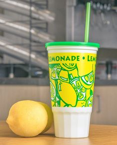 a lemon sitting next to a cup on a table