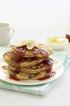 a stack of pancakes covered in syrup and banana slices