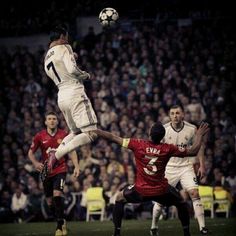 two soccer players jump for the ball in front of an audience at a sporting event