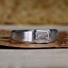 a diamond ring sitting on top of a piece of wood