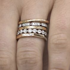 a woman's hand with three different rings on her fingers and one has a diamond in the middle