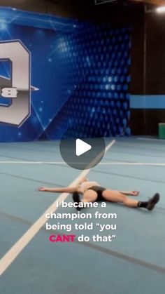 a woman laying on the ground in front of a blue wall with a sign that says, i become a champion from being told you can't do that