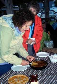 two people are preparing food on a table