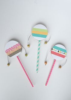 three candy lollipops with colorful designs on them sitting next to each other