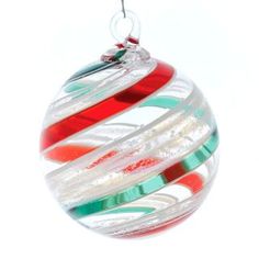 a glass ornament hanging from a metal hook on a white background with red, green and blue swirls