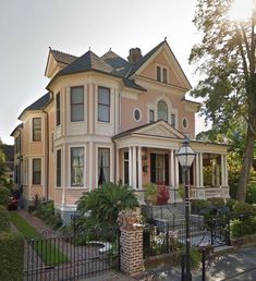 a large pink house sitting on the corner of a street