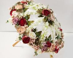 an umbrella made out of flowers on a white background with a wooden stick in the foreground