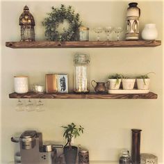 two wooden shelves filled with plants and other items on top of a white countertop