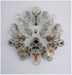 a clock made out of glass sitting on top of a wall