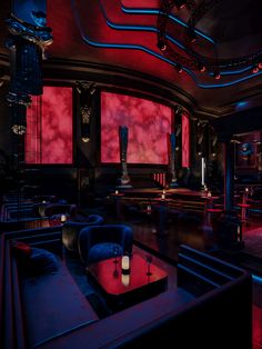 a dimly lit room with red and blue lighting on the walls, couches and tables