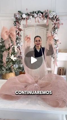 a woman standing in front of a christmas tree with pink bows on it and the caption, continuaremos