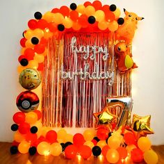 an orange and black birthday decoration with balloons