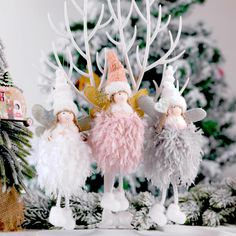 three little fairy figurines standing next to a christmas tree