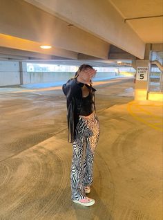 a woman standing on a skateboard in an empty parking garage