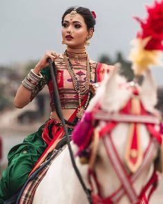 a woman riding on the back of a white horse next to a man in costume