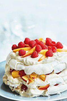 a layered pav with fruit on top and whipped cream in the middle is sitting on a plate