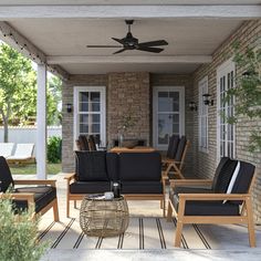 an outdoor living area with black furniture and a ceiling fan