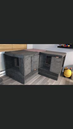 two large concrete boxes sitting on top of a hard wood floor