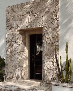 an entrance to a building with a cactus next to it