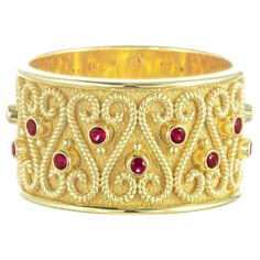 This elegant gold band ring, adorned with shimmering rubies, is the perfect choice for a sophisticated woman. Crafted from luxurious materials, it adds a touch of opulence to any wardrobe. An exquisite piece of craftsmanship, this beautiful ring is sure to make a standout statement. Metal: 18K Gold Gemstones: Rubies weight 0,37 ct Ring Size: 7.5 (free sizing) Discover the art of personalization as you select your dream jewelry, choosing the perfect gemstone that resonates with your unique style. Luxury Yellow Gold Ruby Ring With Round Band, Luxury Gold Ruby Ring With Round Band, Formal Gold Rings With Ruby, Formal Gold Ruby Rings, Gold Ruby Rings With 17 Jewels, Gold Ruby Ring For Formal Events, Gold Ruby Rings With Round Band, Luxury Gold Band Rings, Gold Ruby Ring With 17 Jewels For Anniversary