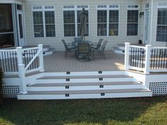 a deck with steps leading up to a table and chairs