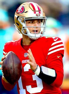 a close up of a football player holding a ball