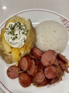 a white plate topped with meat, potatoes and rice