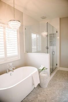 a white bath tub sitting next to a walk in shower