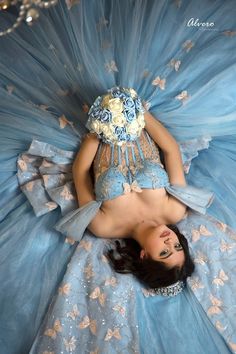 a woman laying on top of a blue dress