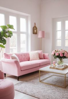 a living room filled with pink furniture and lots of flowers on top of a coffee table