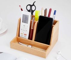 a wooden pen holder with cell phones and pens