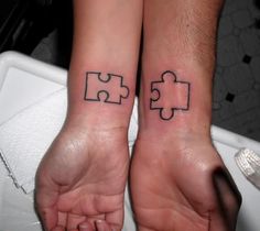 two people holding hands with matching tattoos on their wristes that have puzzle pieces tattooed on them