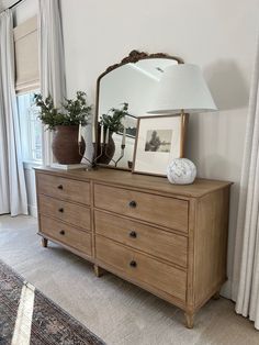 a dresser with a mirror and vases on it