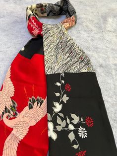 Stunning and comfortable silk scarf made from  8 vintage Japanese silk kimono.  It is long and so supple. There is a lovely black, red and white panel with blossoms all over it. There is 1  floral Meissen ( ikat)  floral silk panel and one ikat polka dot panel. There one red  and white shibori panel as well as a black and white geometric   shibori panel. .There's  a black panel with red and white flowers at one end of scarf. But the most stunning "piece de resistance" is the red panel with black and cream cranes. Scarf measures 6.5" wide by  70"long. All fabrics have been laundered before sewing but I recommend dry cleaning for all pieced scarves. Please contact me with any questions.  Free domestic shipping. Kimono Scarf, Long Silk Kimono, Red And White Flowers, White Panel, Red Panels, Japanese Silk, Black Panels, White Paneling, Silk Kimono