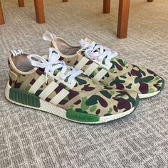 Japanese Streetwear Boutique A Bathing Ape (Bape) Collaborated With Adidas For Two Of The Rarest Nmd R1 Sneakers Ever Released: The Bape X Nmd_r1 'Olive' And 'Black' Colorways. Both Unveiled In July 2016 For A Limited Release Through Bape Retailers And Select Adidas Flagship Stores. The ‘Olive’ Colorway Features Bape’s Iconic Camouflage Design Across Its Upper With Adidas’ Three Stripes On The Side Panels In White. Streetwear Boutique, Ape Bape, Adidas Three Stripes, Camouflage Design, Nmd R1, Japanese Streetwear, Adidas Nmd, Bathing Ape, A Bathing Ape