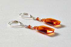 "Orange Swarovski crystal earrings are the perfect gift for an orange lover! Great orange bridesmaid jewelry! These beautiful earrings are designed and handcrafted by me wire wrapping astral pink Swarovski crystals to sterling silver lever back ear wires. Drop length of earrings are approximately 1\" from ear wires. Pictures don't do justice to the color and sparkle of these Swarovski crystals! Color is a gorgeous orange with pink over tones. Would make a lovely gift for someone special! Please Nickel Free Orange Jewelry For Party, Orange Drop Earrings For Anniversary, Orange Drop Earrings For Wedding, Nickel-free Orange Jewelry For Party, Orange Pierced Earrings For Wedding, Unique Orange Dangle Jewelry, Orange Crystal Earrings, Unique Orange Drop Earrings, Elegant Orange Sterling Silver Earrings