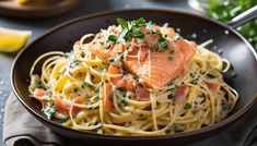 a plate of pasta with salmon and parmesan cheese on the side, garnished with fresh herbs