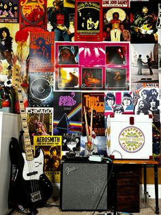 a room filled with guitars and posters on the wall