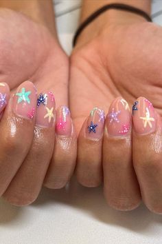 Soft almond-shaped nails with a dreamy beach vibe. The translucent pink base evokes the warmth of sun-kissed skin, each nail playfully decorated with colorful starfish and dots, mimicking a sprinkle of saltwater jewels. Perfect for a seaside escape or simply to carry the essence of the ocean on your fingertips. 🌊✨  // Photo Credit: Instagram @kolorsby_ky Beach Nails Colorful, Non French Tip Nail Ideas, Pink Nails Dots, Summer Beach Nails Short, Pink Cruise Nails, Sting Ray Nails, Nails Gel French Tip, Summer Nails Starfish, Beach Nails Pink