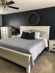 a bedroom with a bed, dressers and a ceiling fan in the middle of it