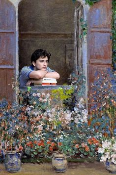 a painting of a young man looking out the window with flowers in front of him