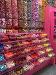 there are many different types of candies in the display case at this candy store