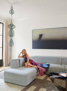 a woman sitting on top of a couch in a living room