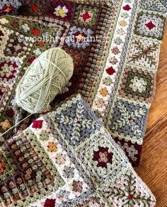 a crocheted blanket and ball of yarn sitting on a wooden floor next to each other