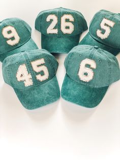 six green hats with white numbers on them