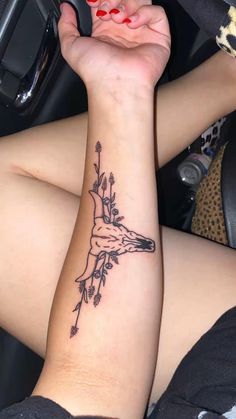 a woman's arm with a deer tattoo on it