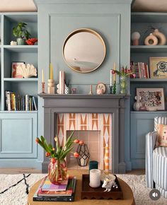 a living room filled with furniture and a fire place in front of a blue wall