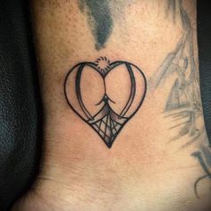 a tattoo on the foot of a person with a heart and arrow in the middle