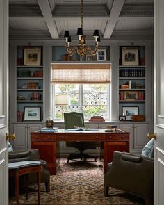 a home office with built in bookshelves, desk and two chairs next to a window